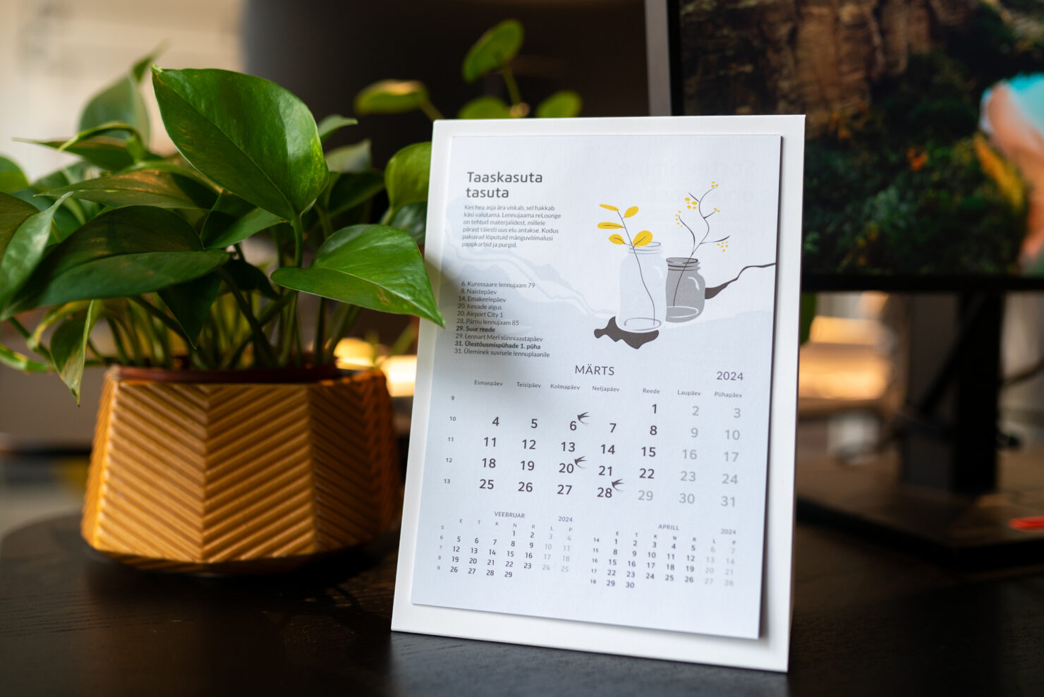 A table-calendar next to a plant